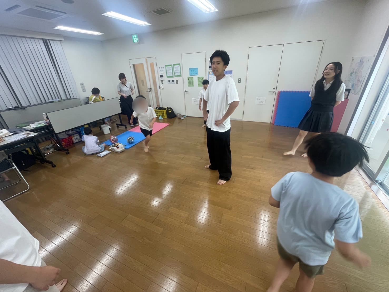 机を囲んで英語の工作に取り組む子どもたち